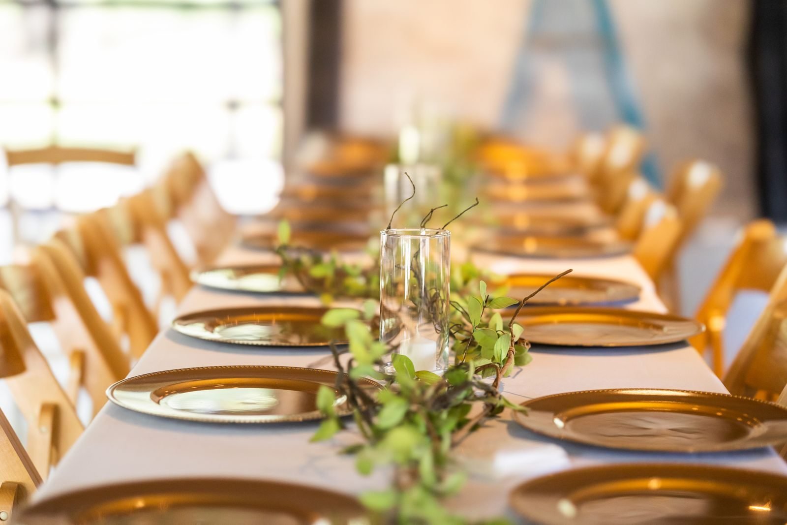 Mesa de banquete de boda decorada con follaje verde natural